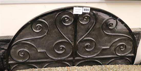 A 16th century style black painted cast iron fire back and a wrought iron spark guard fire back W.88cm spark guard 71cm